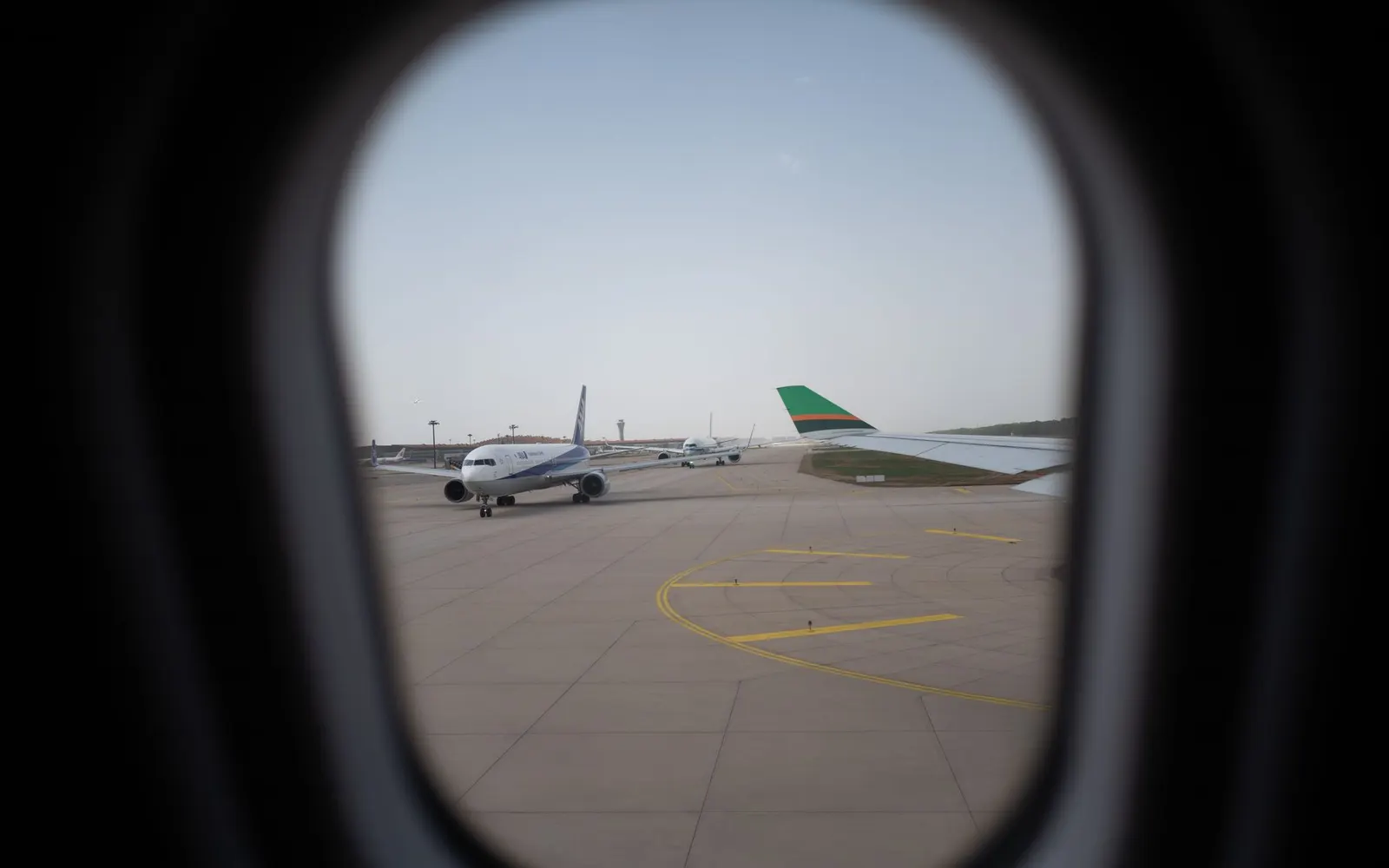 Écran d'aéroport avec les départs et un avion au décollage